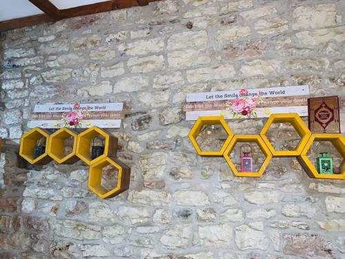 a stone wall with four yellow windows on it at Guest House and Hostel VAL-MAR in Gjirokastër