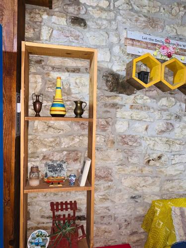 a wooden shelf against a stone wall at Guest House and Hostel VAL-MAR in Gjirokastër