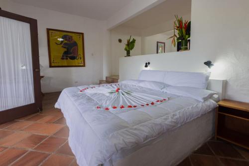a large white bed with a red bow on it at Condiminium Villas Mymosa in Manuel Antonio
