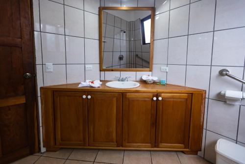a bathroom with a sink and a mirror at Condiminium Villas Mymosa in Manuel Antonio