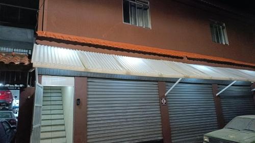 Pousada do Gil في تيريسوبوليس: باب جراج على مبنى به موقف