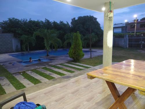 a picnic table in a backyard with a swimming pool at Cabaña Milan in Aguachica