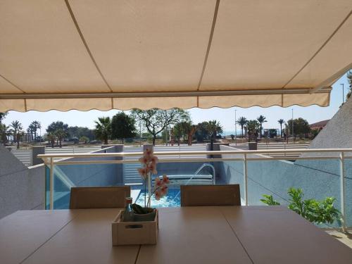 stół i krzesła z parasolem na balkonie w obiekcie Villa de lujo frente al mar w mieście Barrio-Mar