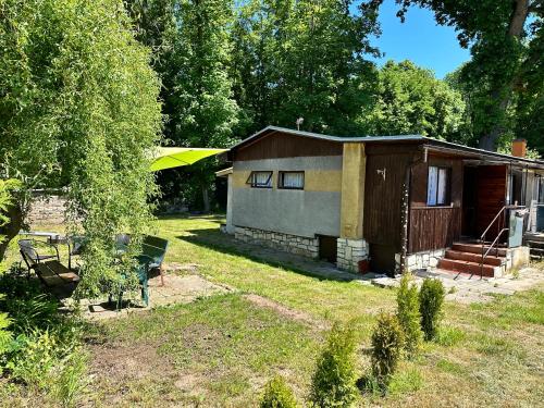 a small house in a yard next to a yard at Chata U Řeky in Volenice