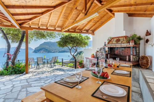 a dining room with a table and a view of the water at Remezzo Cottage in Skopelos Town