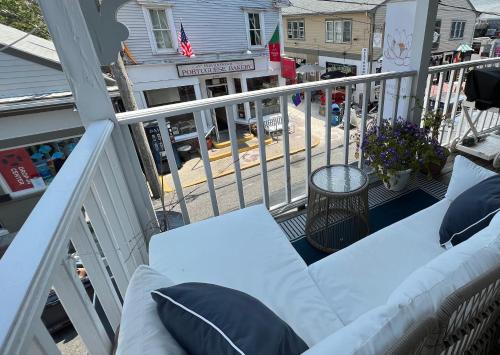 a white couch sitting on a balcony with a street at Lotus Provincetown in Provincetown