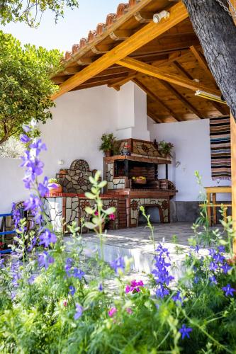 a garden with a wooden pergola and purple flowers at Remezzo Cottage in Skopelos Town