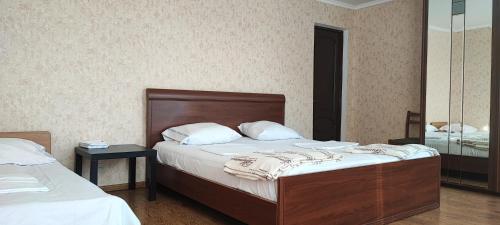 1 dormitorio con 2 camas y espejo en Отдых от городской суеты, en Gagra