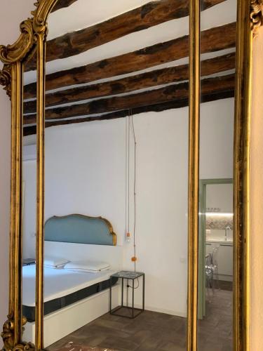 a large gold mirror in a bedroom with a bed at Calderai 82 suites 1 e 2 in Palermo
