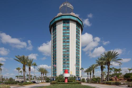 a tall building with palm trees in front of it at Four Points by Sheraton Orlando International Drive in Orlando