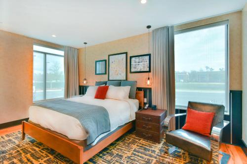 a bedroom with a bed and a chair and a window at SpringHill Suites by Marriott Wilmington Mayfaire in Wilmington