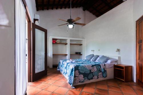 - une chambre avec un lit et un ventilateur de plafond dans l'établissement Condiminium Villas Mymosa, à Manuel Antonio