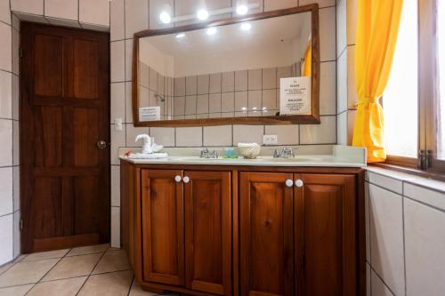 W łazience znajduje się umywalka i lustro. w obiekcie Condiminium Villas Mymosa w mieście Manuel Antonio