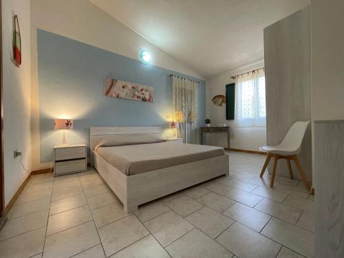 ein Schlafzimmer mit einem Bett, einem Tisch und einem Stuhl in der Unterkunft Appartamenti magnolie-La pineta in Valledoria