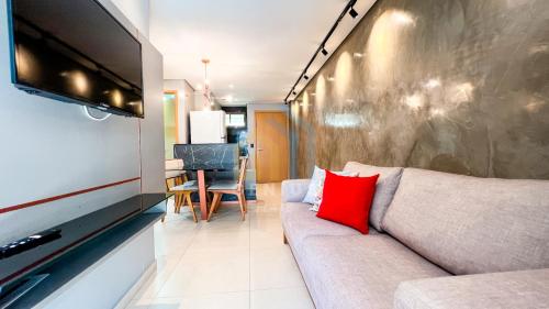 uma sala de estar com um sofá e uma televisão de ecrã plano em Eco Summer Tambaú - Apartamentos de 2 Quartos por Genius Flats em João Pessoa