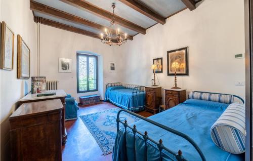 1 Schlafzimmer mit 2 Betten, einem Schreibtisch und einem Kronleuchter in der Unterkunft Stunning Home In Ponti Sul Mincio With Wifi in Ponti Sul Mincio