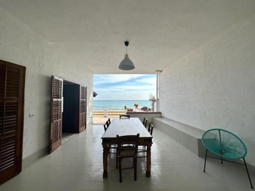 a dining room with a table and a view of the ocean at Le Sorelle Villa sul mare in Porto Empedocle