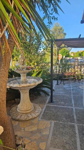 a stone bench and a fountain in a park at Luminoso chalet in Alcudia