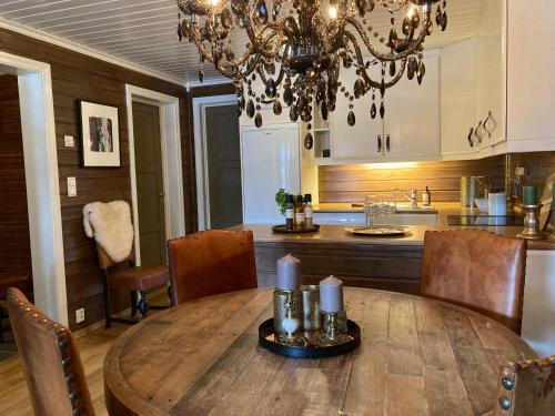 a kitchen with a wooden table and a chandelier at Bo lunt og koselig på Filefjell in Tyinkrysset