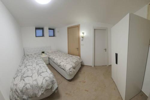 1 dormitorio con 2 camas en una habitación blanca en The Premier Apartment In RBS A, en Bet Shemesh
