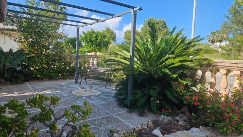 a garden with a bench and some plants at Luminoso chalet in Alcudia