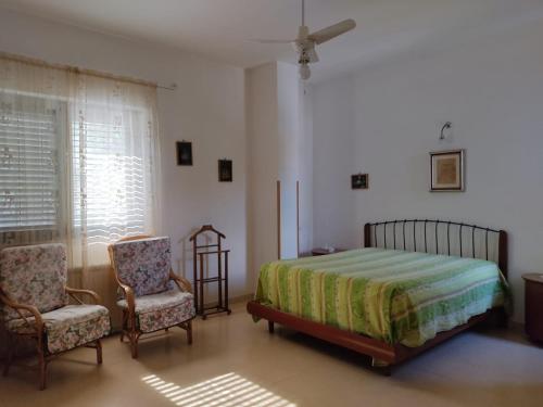 パリヌーロにあるVivere il mareのベッドルーム1室(ベッド1台、椅子2脚付)