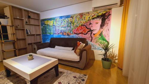 プリシュティナにあるPainte's Homeのソファと壁に絵が飾られたリビングルーム