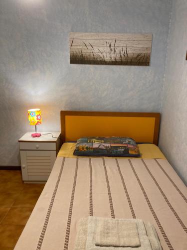 a small bedroom with a bed and a lamp at Casa Maris Stella in Platamona