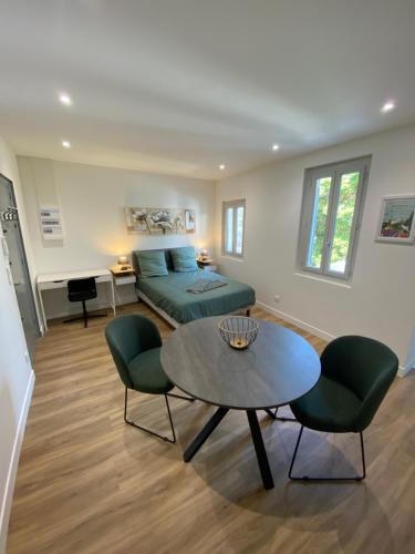 un salon avec un lit, une table et des chaises dans l'établissement Studio terrasse, intra-muros, climatisé avec Wifi, à Avignon