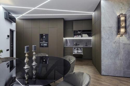 a dining room with a black table and chairs at Odesa Pearl Apartments in Odesa