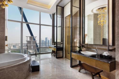 La salle de bains est pourvue d'une baignoire, d'un lavabo et d'une grande fenêtre. dans l'établissement JW Marriott Hotel Shenzhen Bao'an International Airport, à Bao'an