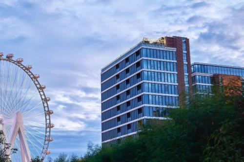 a tall building with a ferris wheel in front of it at JW Marriott Hotel Shenzhen Bao'an International Airport in Bao'an