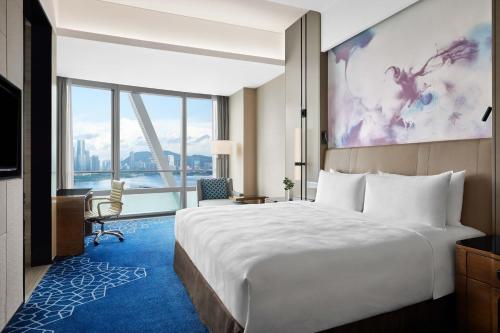 Cette chambre comprend un grand lit et une grande fenêtre. dans l'établissement JW Marriott Hotel Shenzhen Bao'an International Airport, à Bao'an