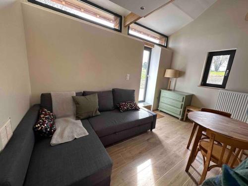 a living room with a couch and a table at Gite lumineux et confortable - La ferme de Montigny in Neauphe-sur-Dives