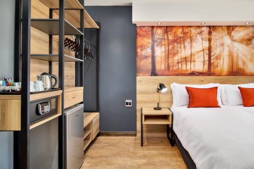 a bedroom with a bed and a book shelf at Protea Hotel by Marriott Pretoria Loftus Park in Pretoria