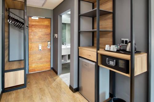 a room with a bathroom with a sink and a mirror at Protea Hotel by Marriott Pretoria Loftus Park in Pretoria
