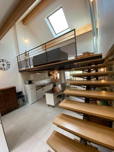 une pièce avec un escalier dans un bâtiment avec une horloge dans l'établissement Maison de village proche VILLEFRANCHE DE ROUERGUE, à Savignac