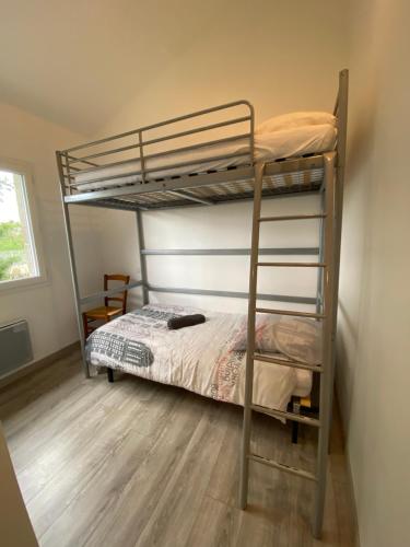 une chambre avec deux lits superposés et un plancher en bois dans l'établissement Maison de village proche VILLEFRANCHE DE ROUERGUE, à Savignac