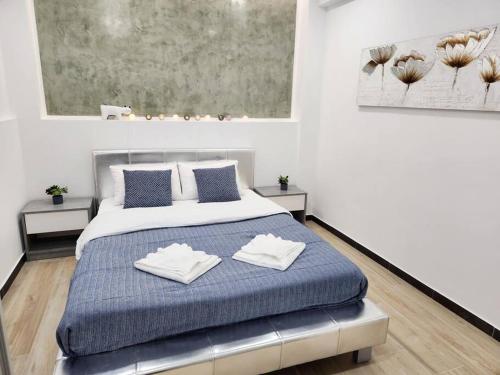 1 dormitorio con 1 cama con 2 toallas en Kipseli's Home en Athens