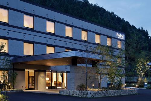 a large office building with a mountain in the background at Fairfield by Marriott Gifu Gujo in Gujo