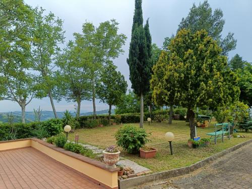a garden with trees and a brick walkway at Rocca di Luna a Gemmano in Gemmano