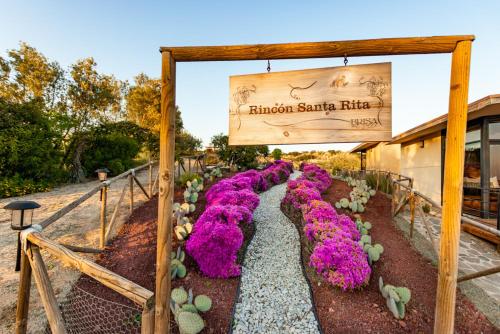 a garden with purple flowers in front of a building at Brisa Del Valle Hotel Boutique in Valle de Guadalupe