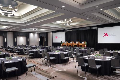 a conference room with tables and chairs and a screen at Austin Marriott South in Austin