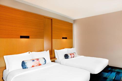 duas camas num quarto de hotel com almofadas brancas em Aloft Arundel Mills BWI Airport em Hanover
