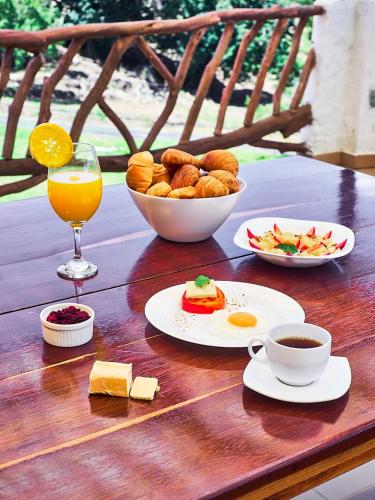 una mesa con un tazón de pan y un vaso de zumo de naranja en Macúa, en Chipatá