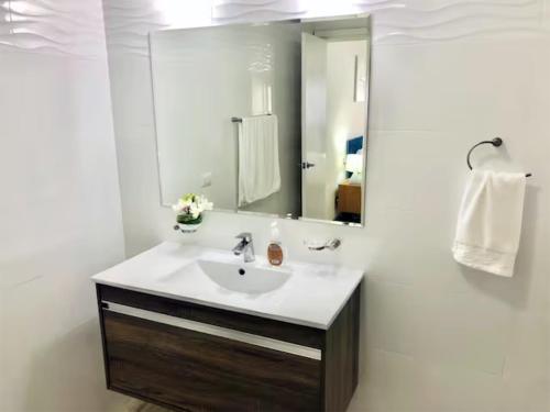 ein Bad mit einem Waschbecken und einem Spiegel in der Unterkunft Sublime Apartment City Center - PH Quartier Atlapa in Panama-Stadt
