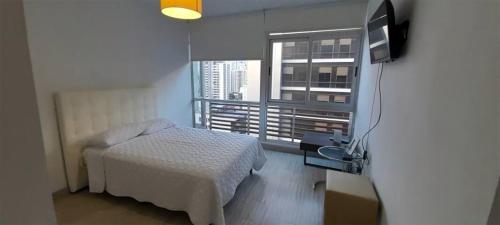 um quarto com uma cama, uma televisão e uma janela em Sublime Apartment City Center - PH Quartier Atlapa na Cidade do Panamá