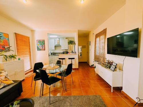 a living room with a table and a kitchen at DeCapi House in Sanlúcar de Barrameda
