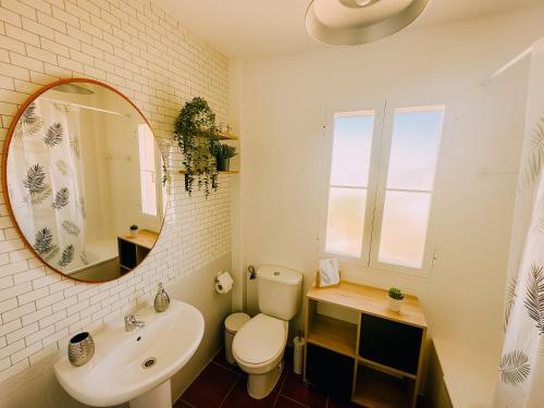 a bathroom with a toilet and a sink and a mirror at DeCapi House in Sanlúcar de Barrameda