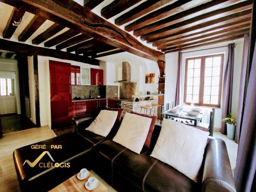 uma sala de estar com um sofá de couro e uma cozinha em Le Graveur Saint Maclou, Hyper centre, Typique Rouennais em Rouen